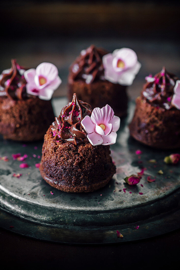 Kleine Brownie-Kuchen mit Schokoladenganache, mit Blüten dekoriert