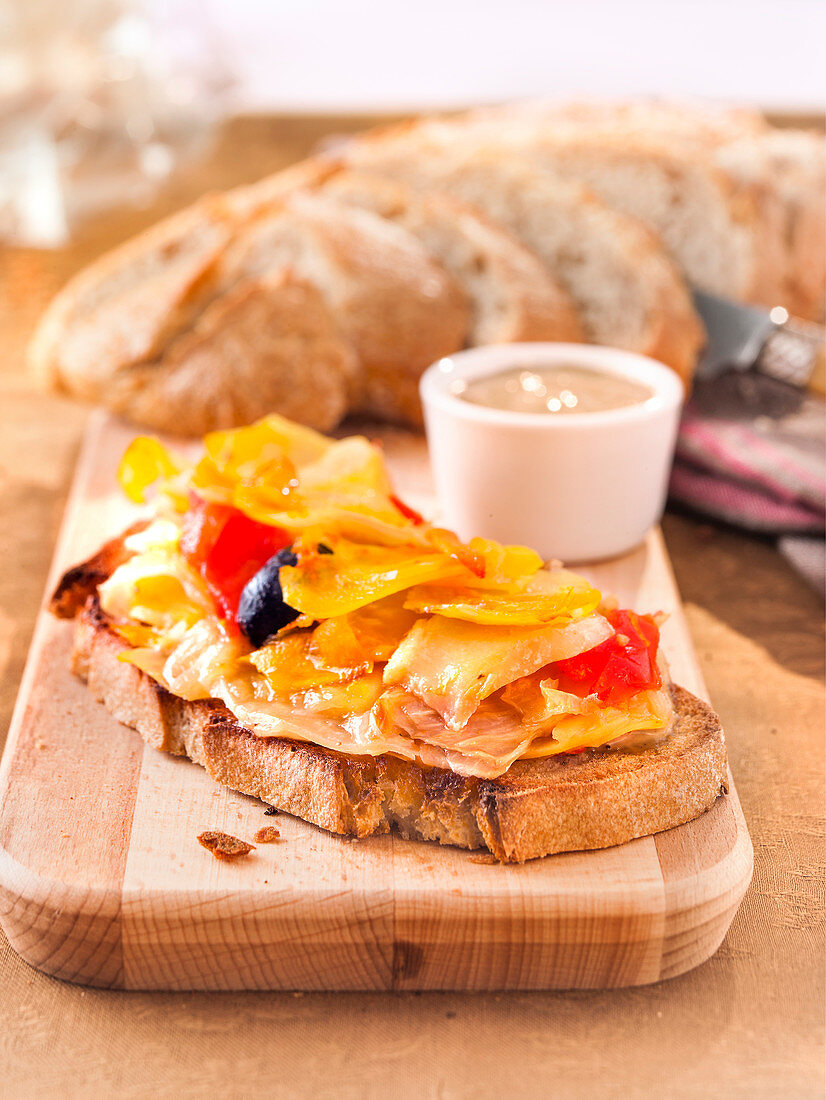 Belegtes Brot mit Stockfischragout und Gemüse