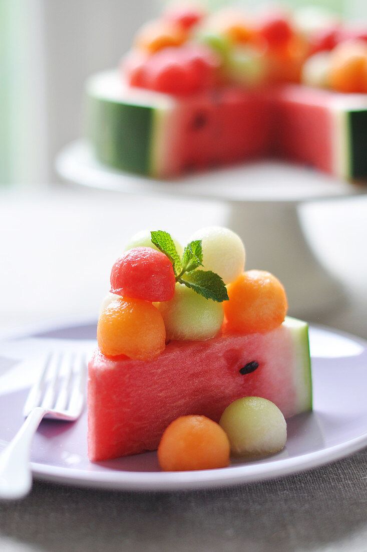 Ein Stück Wassermelone mit Melonenbällchen als Torte