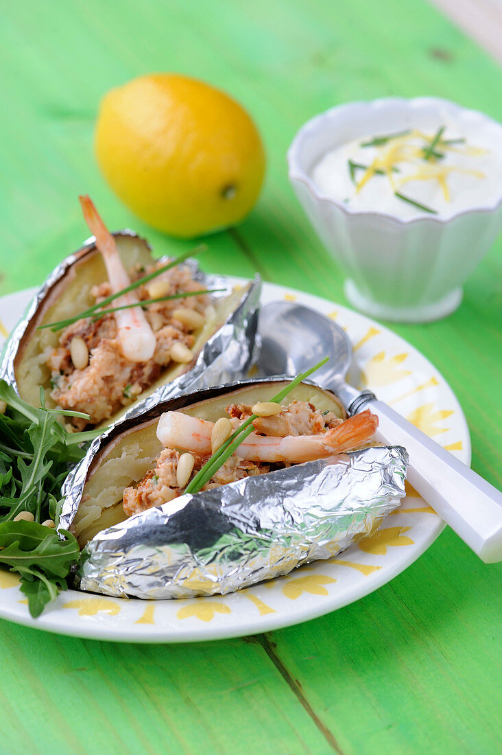 Baked potatoes garnished with shellfish,pine nuts and lemon cream