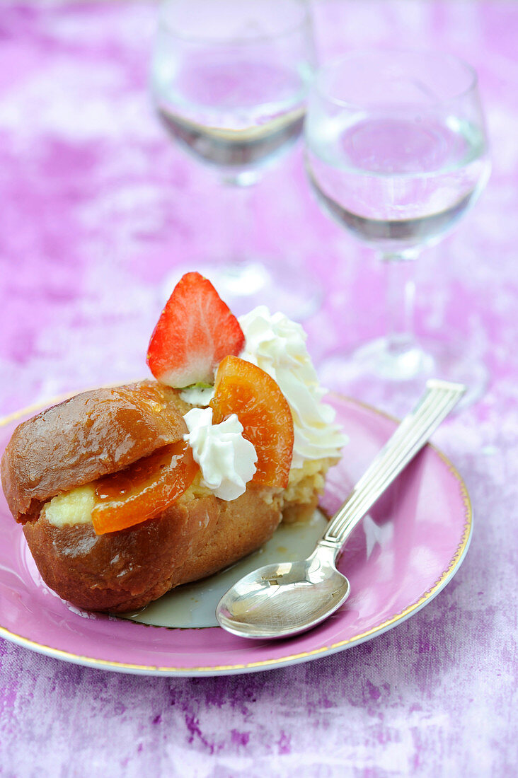 Rum baba with whipped cream,confit orange and strawberries