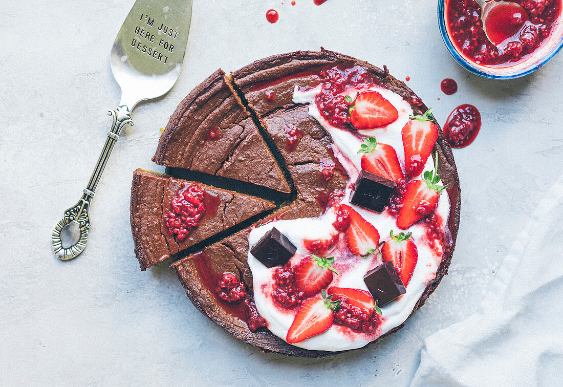 Schokoladen-Mud Cake mit Schlagsahne, Erdbeeren und Himbeersauce