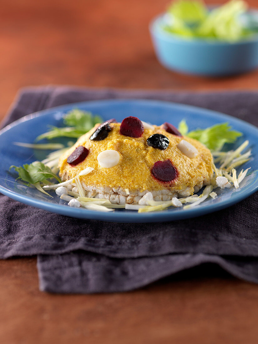 Hokkaidokürbismousse mit Punkten aus schwarzen Oliven, aus Eiweiss und aus Roter Bete auf Puffreis