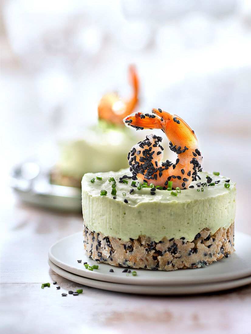 Small avocado and lime cheesecake topped with a shrimp and sprinkled with black sesame seeds