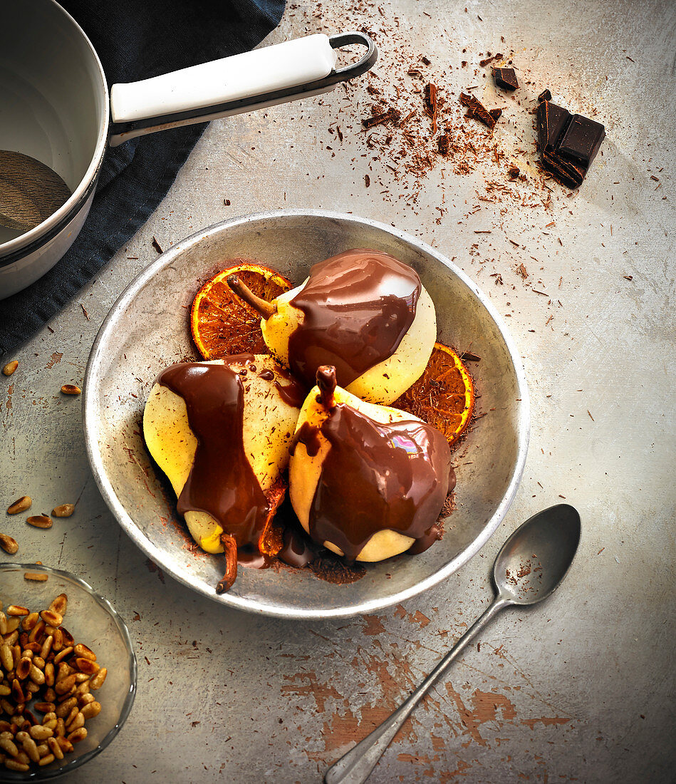 Poached pears with chocolate,roasted oranges and grilled pine nuts