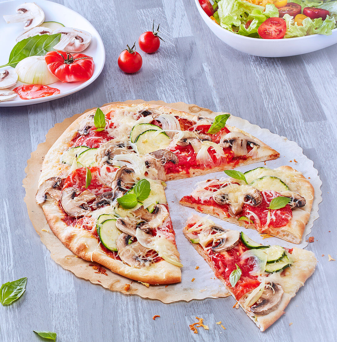 Pizza mit Tomaten, Champignons und Zucchini