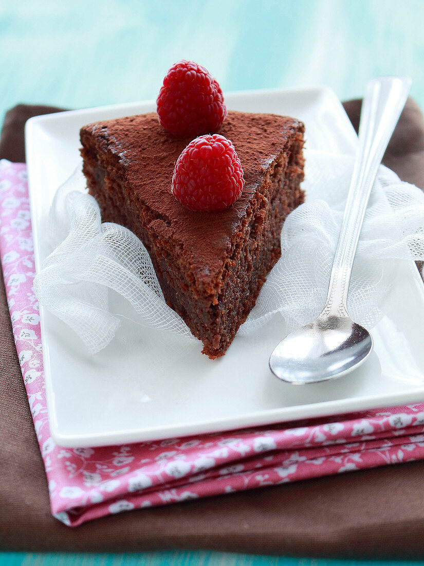Stück Schokoladen-Mandel-Kuchen mit frischen Himbeeren