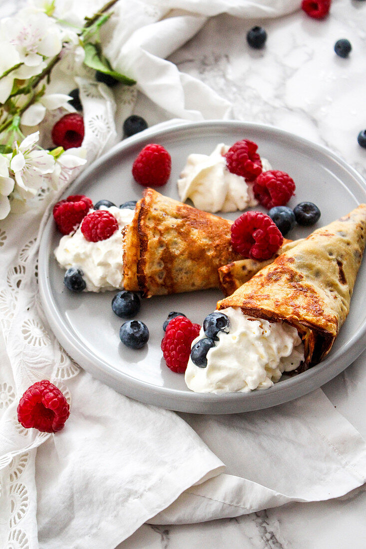 Pancake cones garnished with whipped cream and summer berries