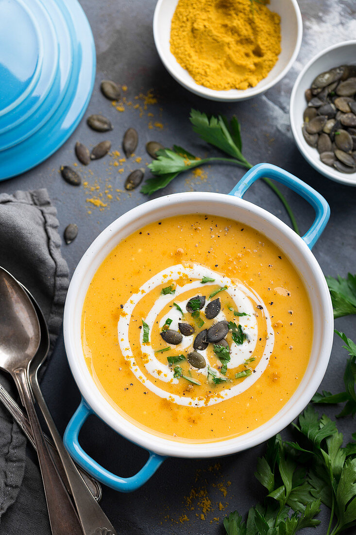 Roasted carrot and pumpkin soup served with spices,squash seeds and cream