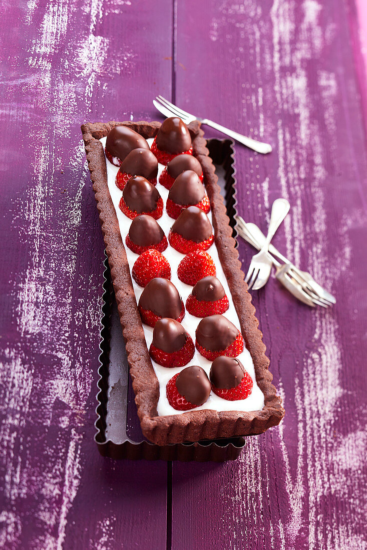 Rectangular chocolate, cottage cheese and coated strawberries tart