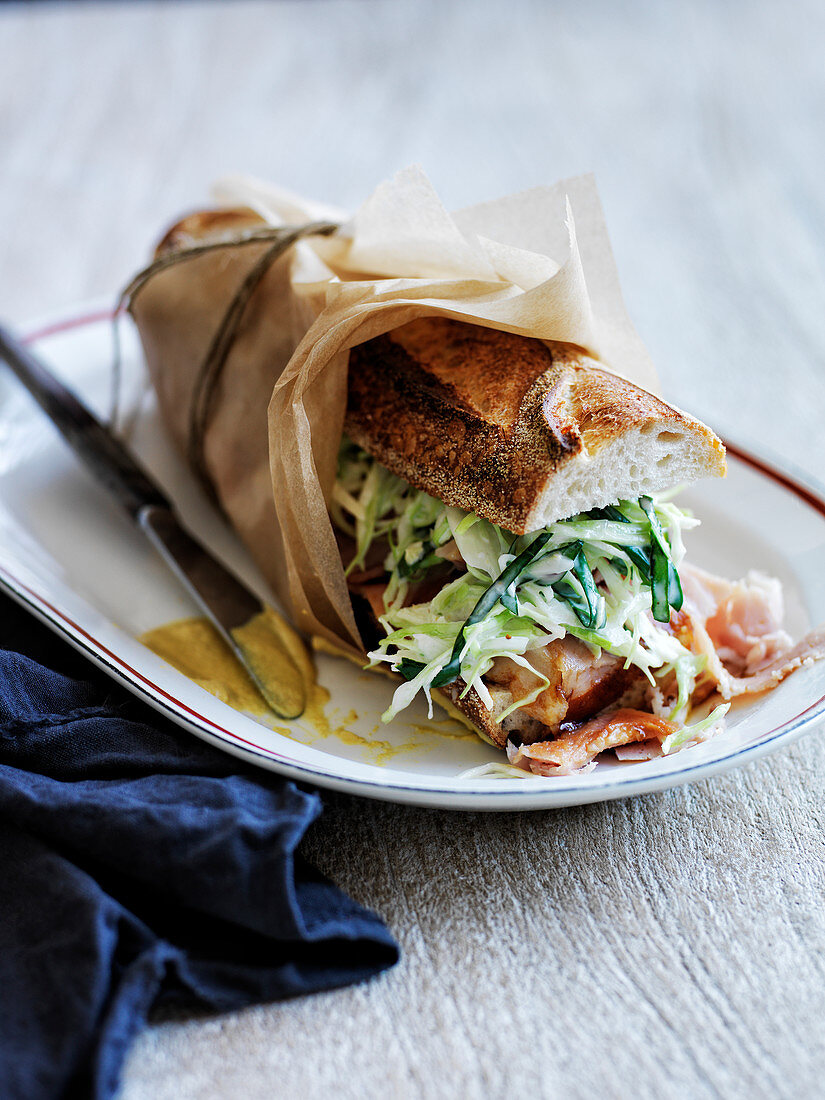 Baguette-Sandwich mit Speck, Krautsalat, Apfel und Basilikum