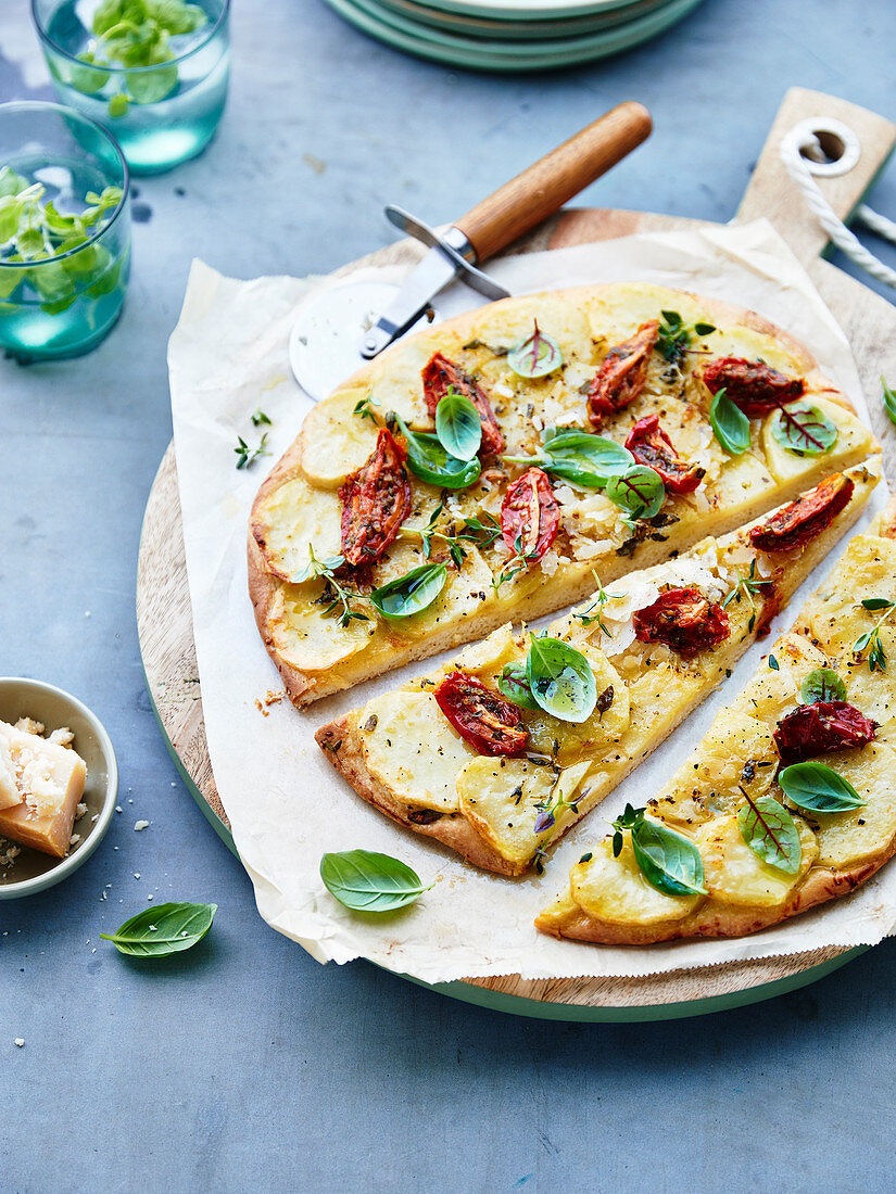 Pizza mit Kartoffeln, Kirschtomaten und Basilikum