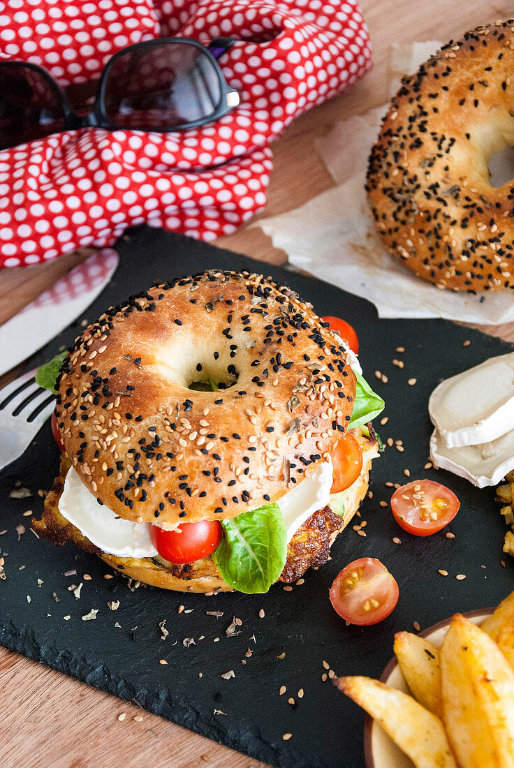 Vegetarischer Bagel mit Ziegenkäse, Kartoffelrösti und Gemüse