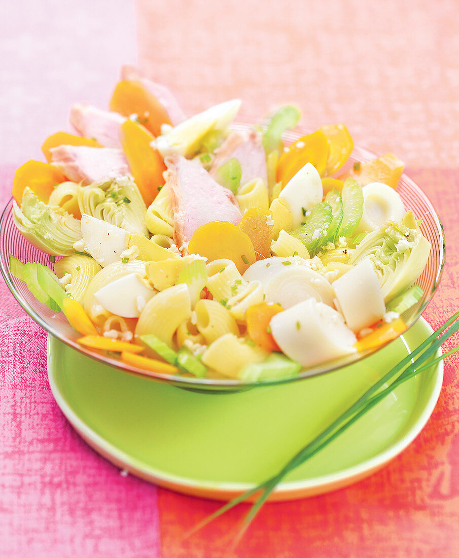 Pasta salad with chicken, hard-boiled egg, carrots, hearts of palm and artichoke hearts