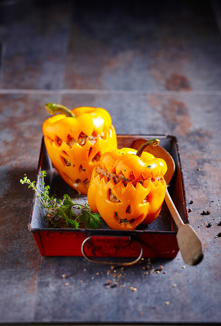 Jack O'lantern-style stuffed yellow peppers for Halloween