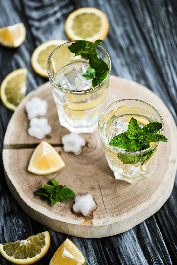 Cold fresh mojito cocktail in glasses on wooden surface