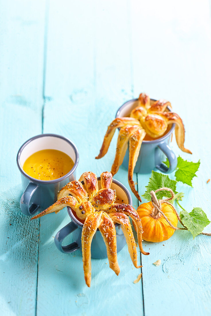 Kürbissuppe dekoriert mit Spinnen aus Blätterteig (Halloween)