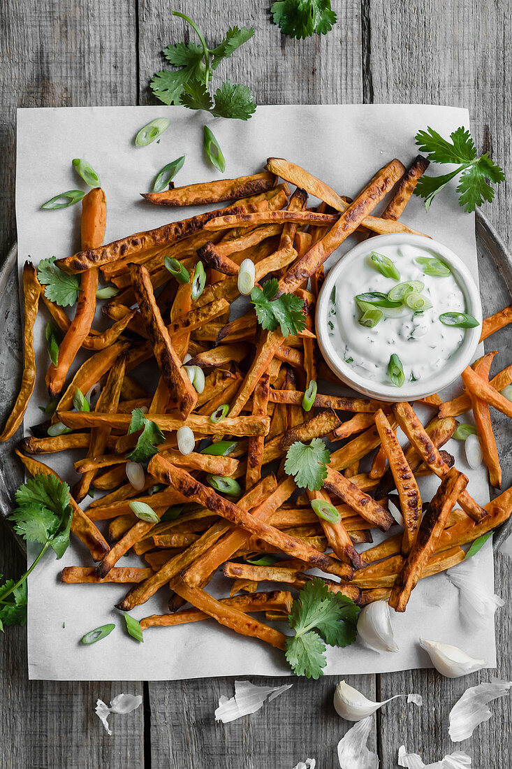 Sweet potato fries roasted in the oven and served with a vegan yogurt with green onions and herbs