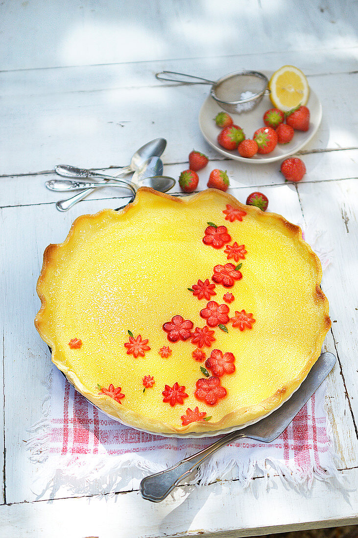 Thin lemon curd pie decorated with strawberries