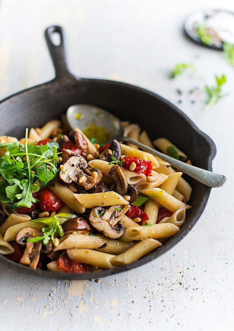 Fried penne with mushrooms, cherry tomatoes and rocket salad