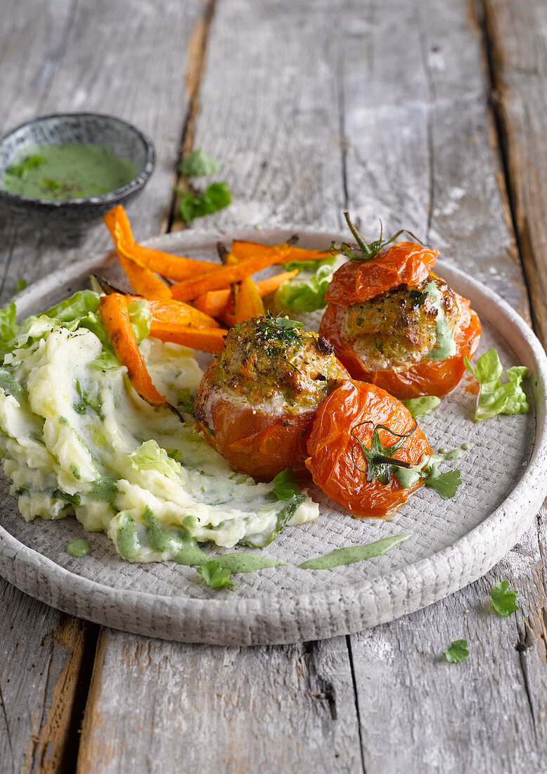 Stuffed tomatoes served with mashed lettuce and roasted carrots