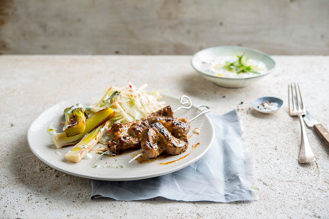 Grilled pork skewers with fennel salad and leeks