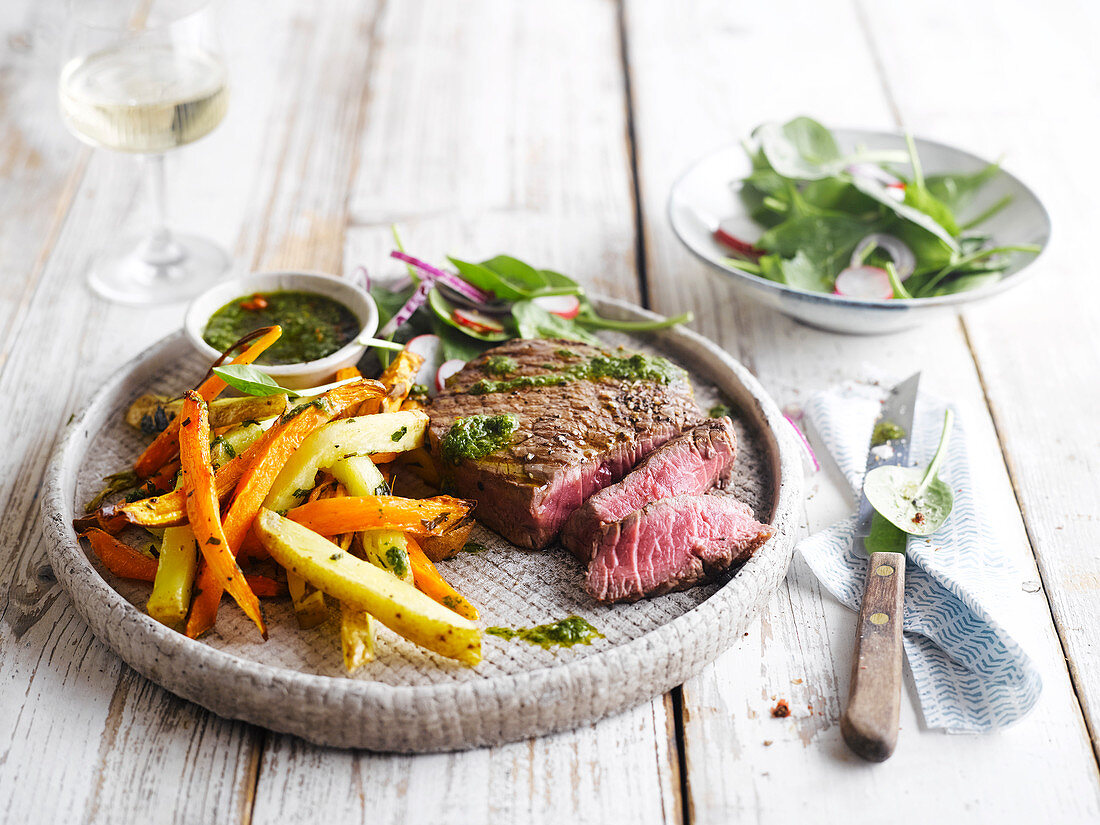 Beef steak with herb sauce and root vegetables