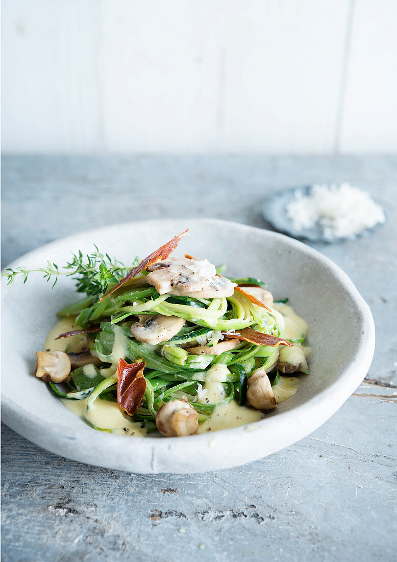 Courgette spaghetti with mushrooms and bacon chips