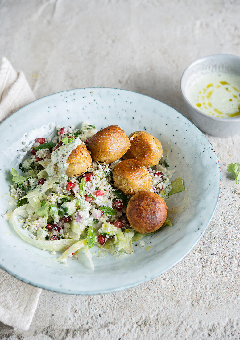 Falafel with and pomegranate semolina and white sauce
