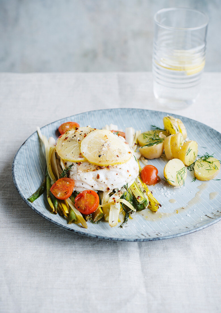 Steamed fish on leek vegetables with tomatoes and potatoes