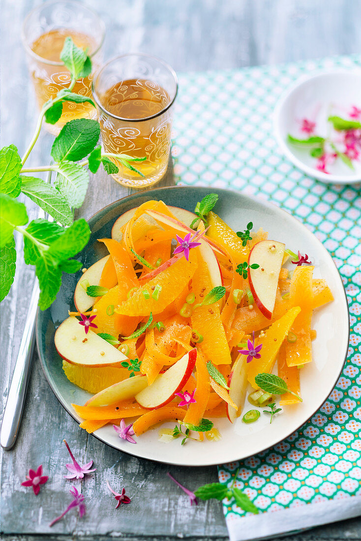 Carrot,apple and orange fruit salad with mint green tea