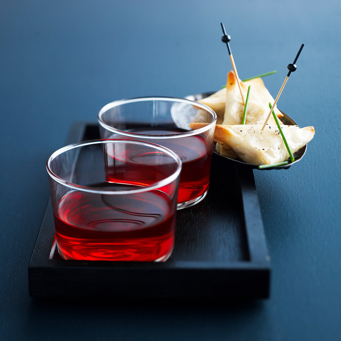 Pastries with cream cheese and chives, served with cider cocktails with grenadine