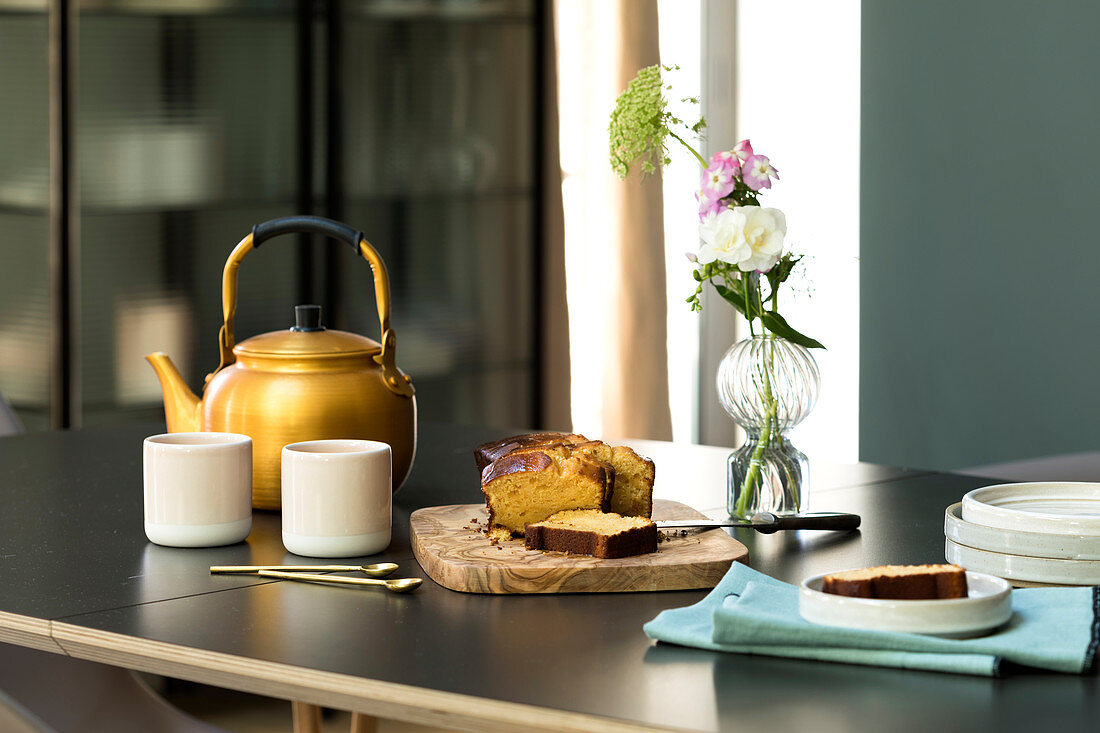 Pumpkin pie and a teapot with cups on a table