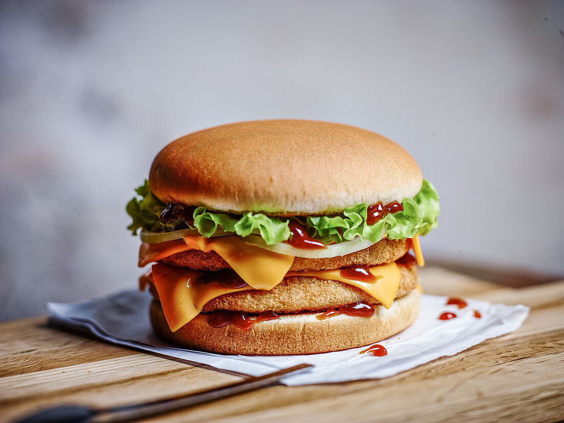 Crispy chicken burger with cheese, ketchup and onions
