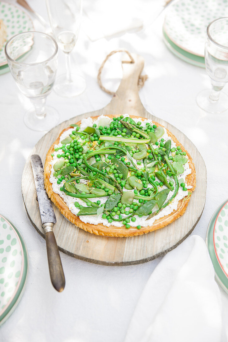 Summer vegetable tart with green vegetables on an outdoor table