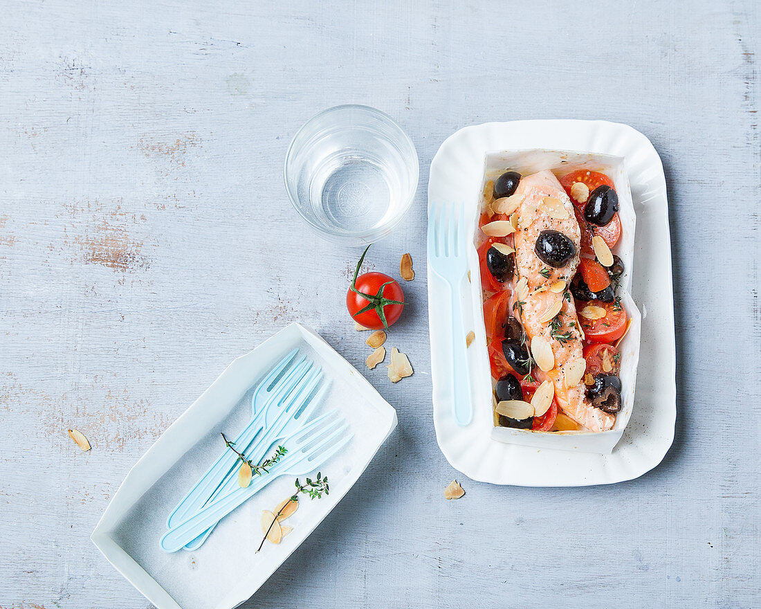 Salmon baked in paper with olives and tomatoes