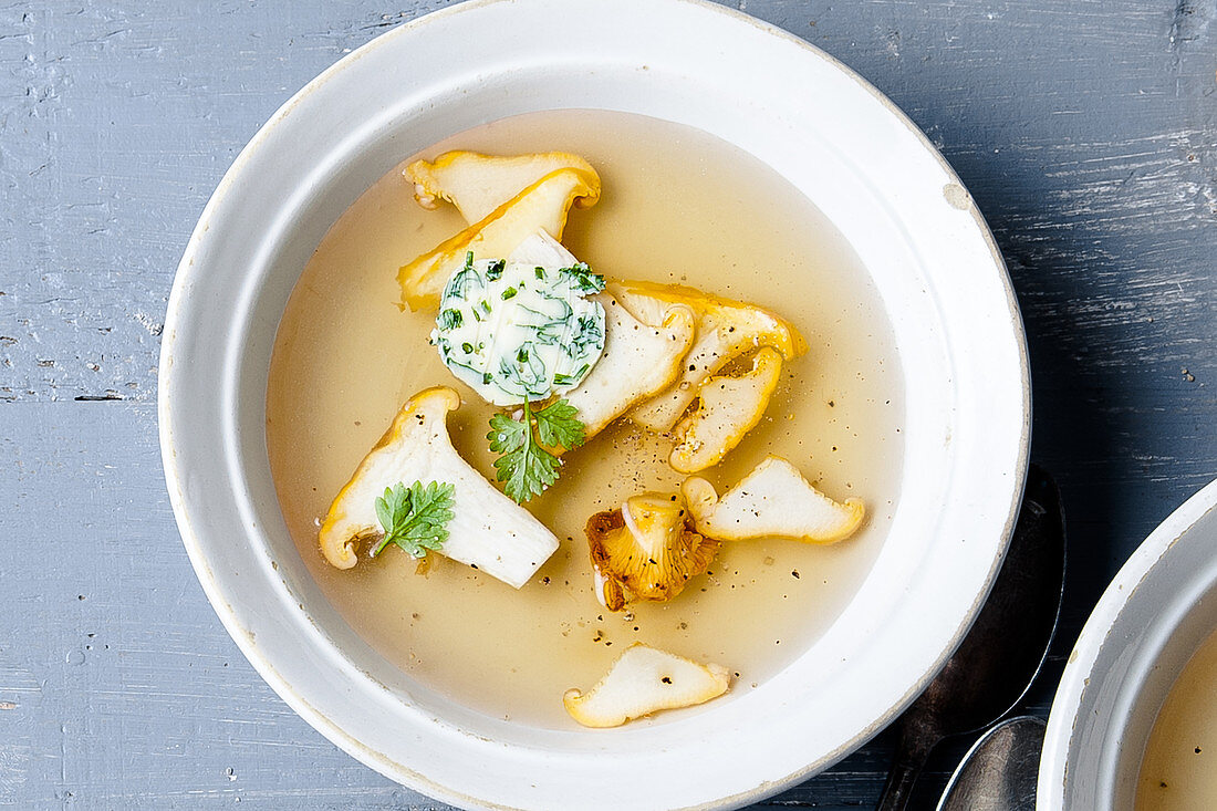 Brühe mit Pilzen und Kräuterbutter