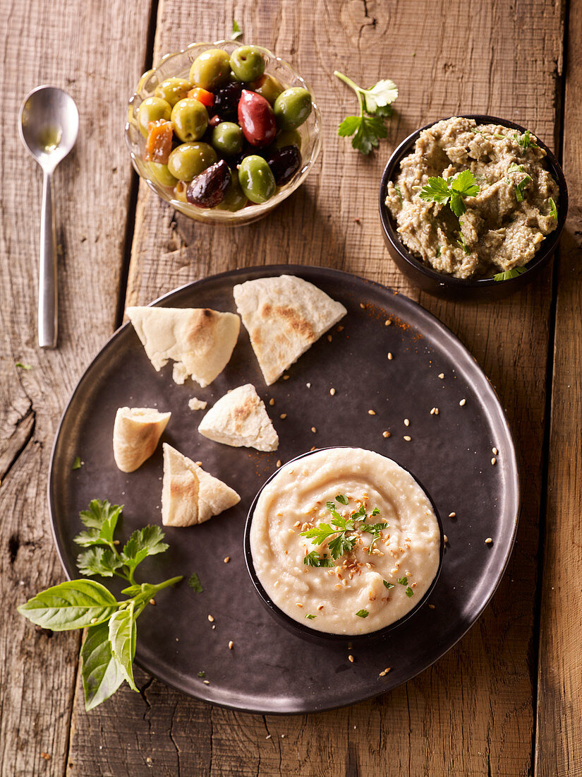 White bean cream and lentil spread served with bread and olives