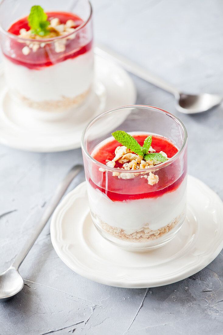 Käsekuchen mit Erdbeersauce serviert in Dessertgläsern