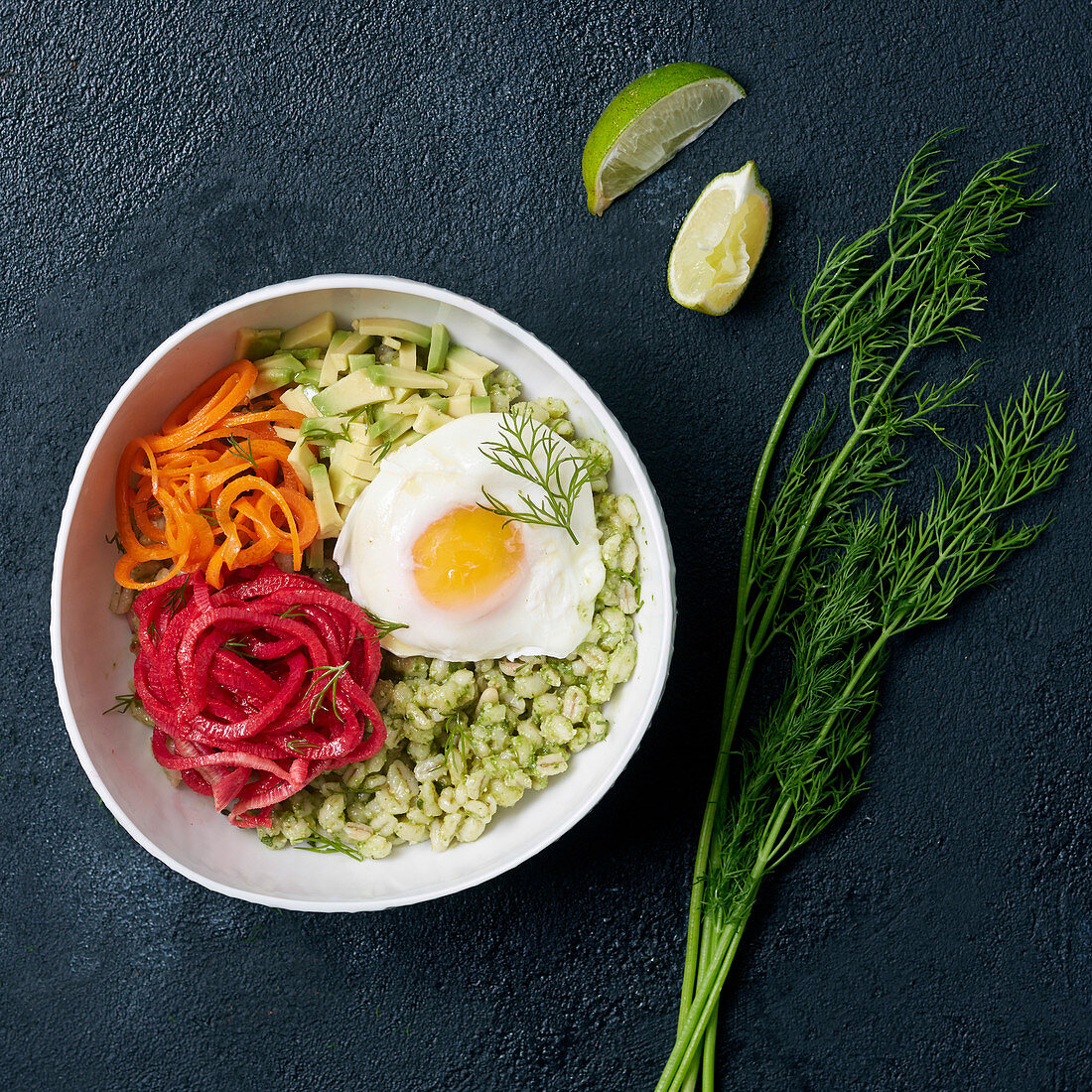 Bowl with wheat, vegetable noodles, avocado, egg and dill sauce