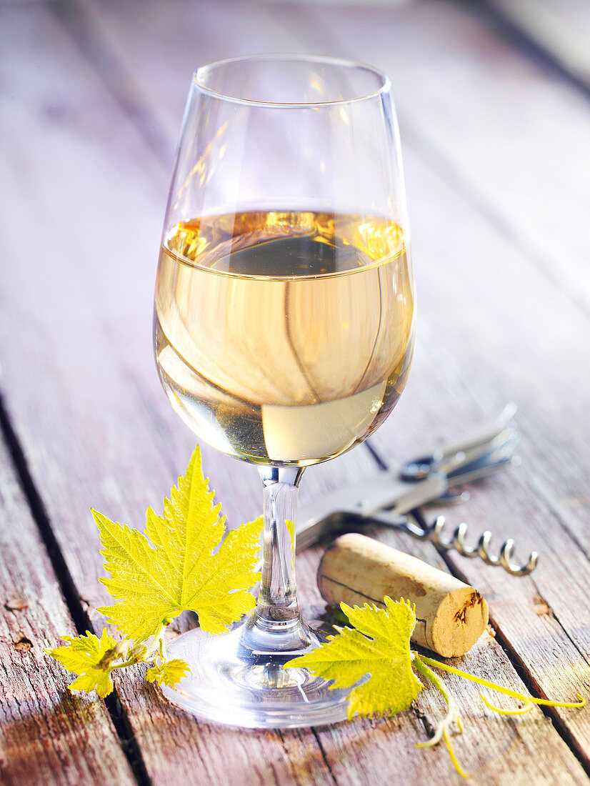 A glass of white wine on a wooden background