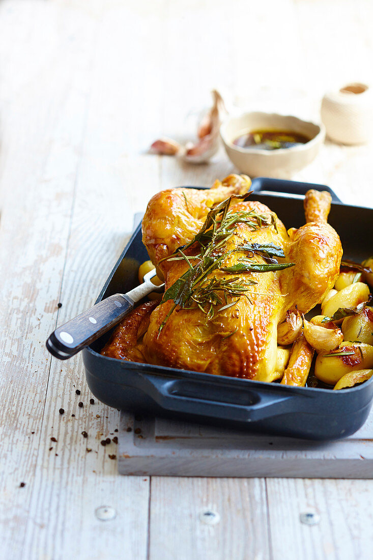 Roast chicken with herbs, garlic and potatoes