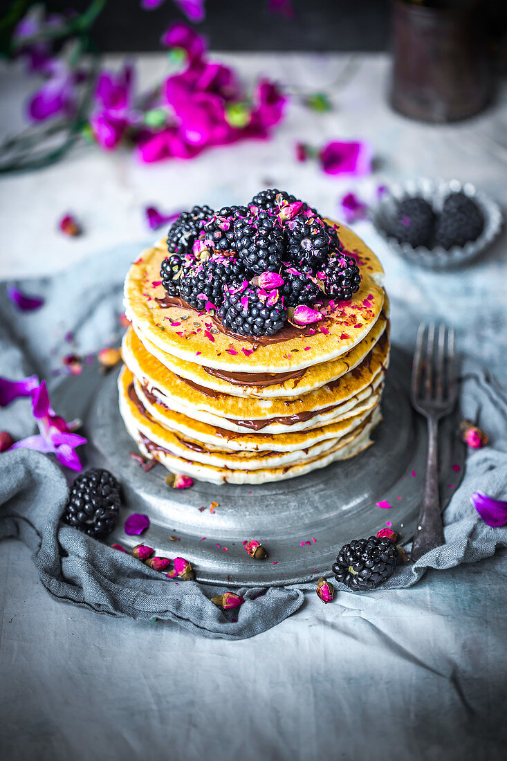 Pancakes with chocolate cream, blackberries and rosebuds