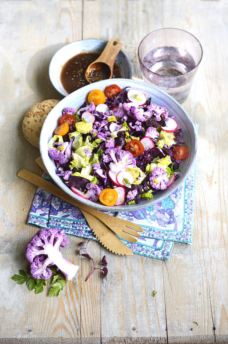 Vegetable salad with purple cauliflower, radishes and cherry tomatoes