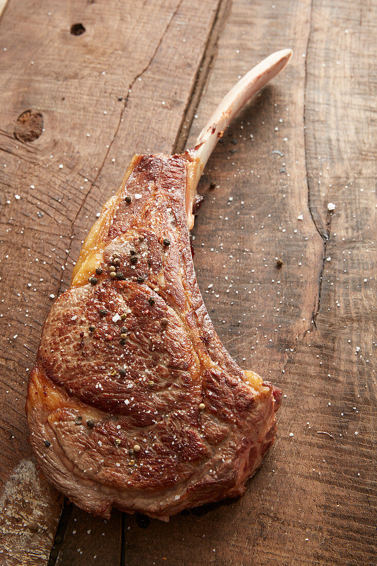 Grilled prime rib on a wooden background
