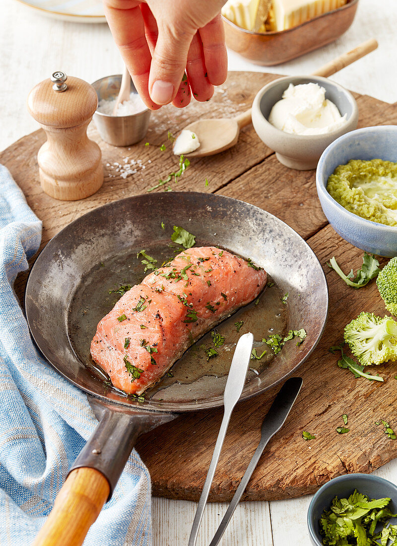 Salmon with herbs in a pan