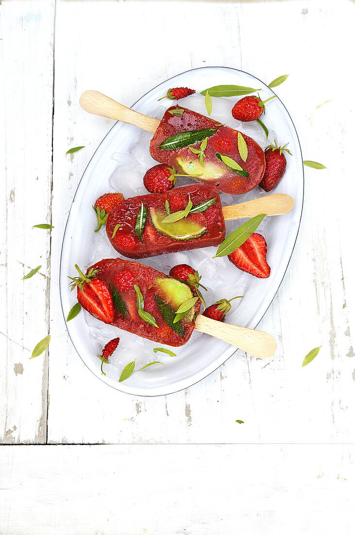 Homemade strawberry ice lollies with lime slices