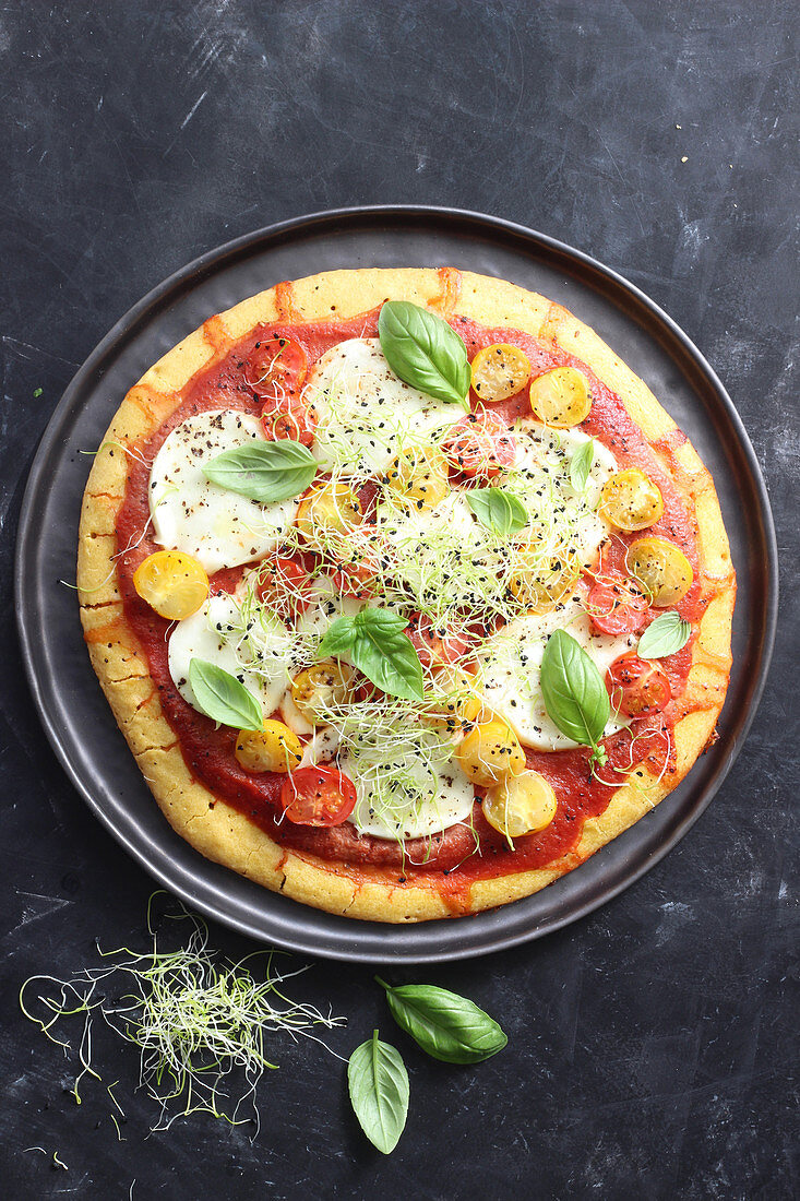 Vegetarian pizza with tomatoes, mozzarella and sprouts