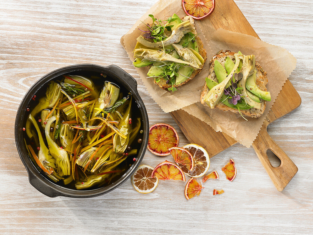 Bread topped with avocado and pickled artichokes