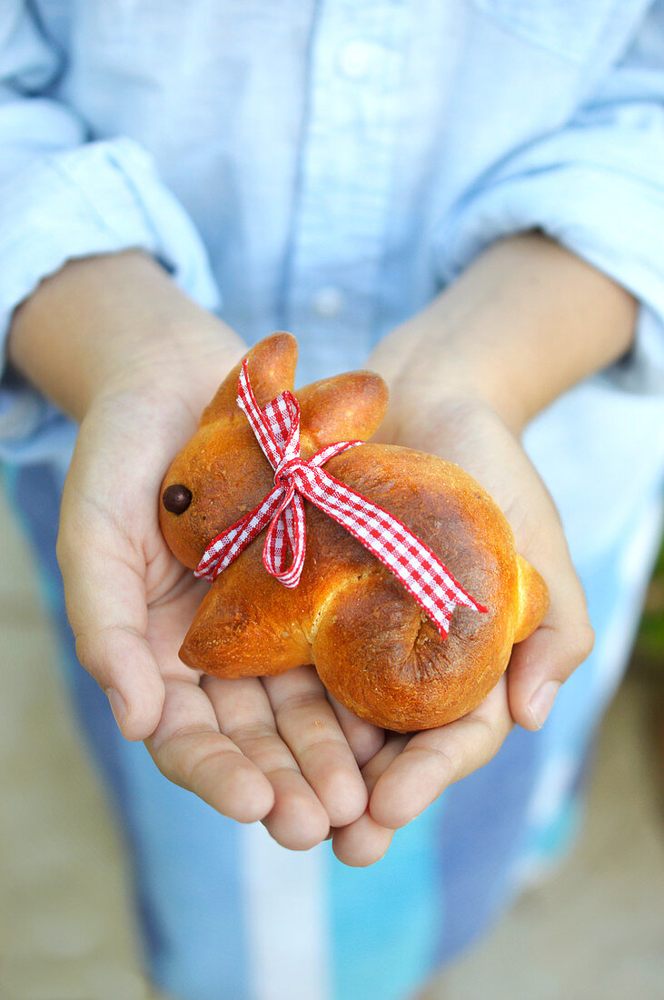 A woman holding bunny-shaped Easter biscuits